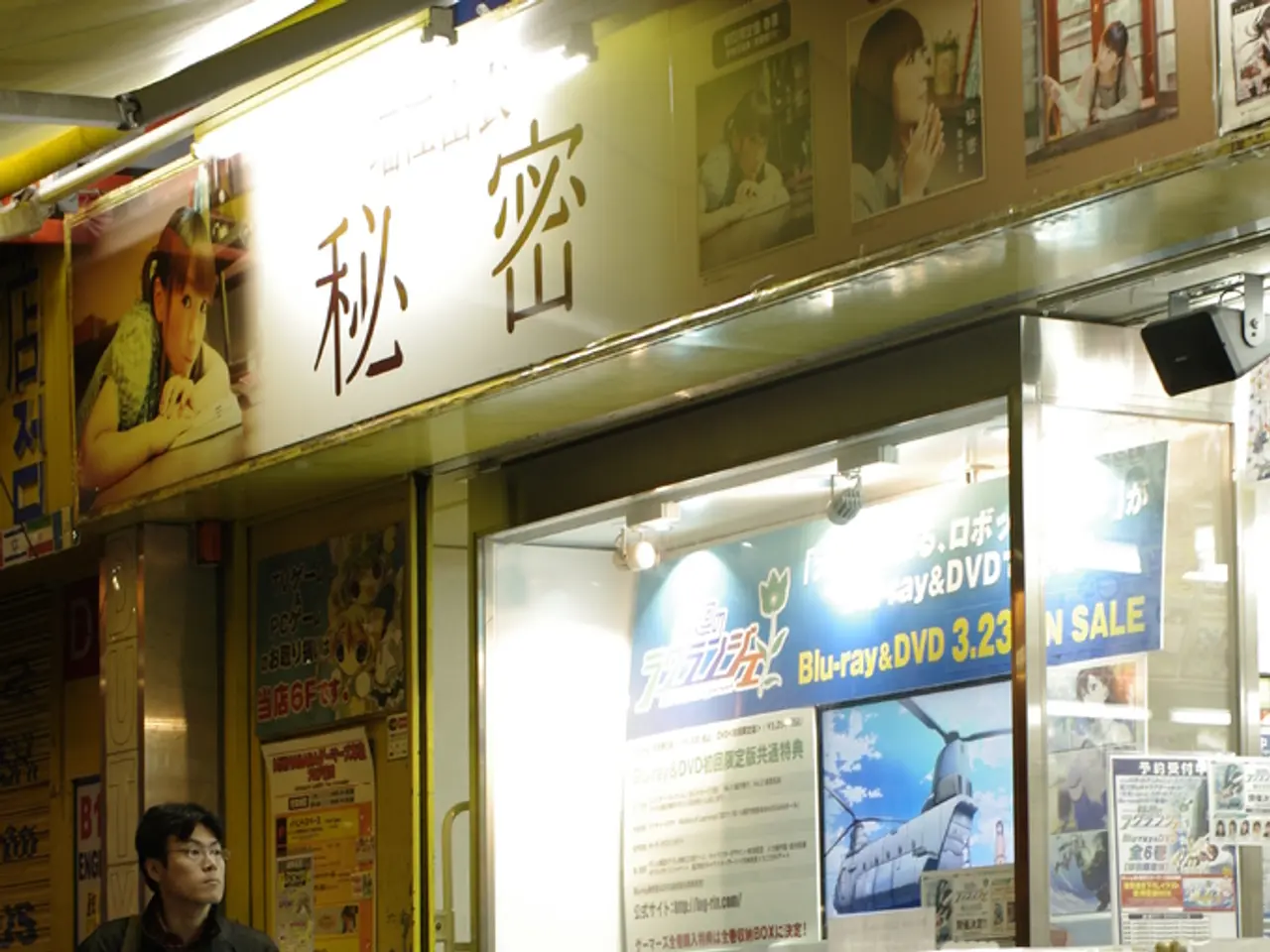 In this image there is a man standing, he is holding a mobile phone, he is wearing a bag, there are...