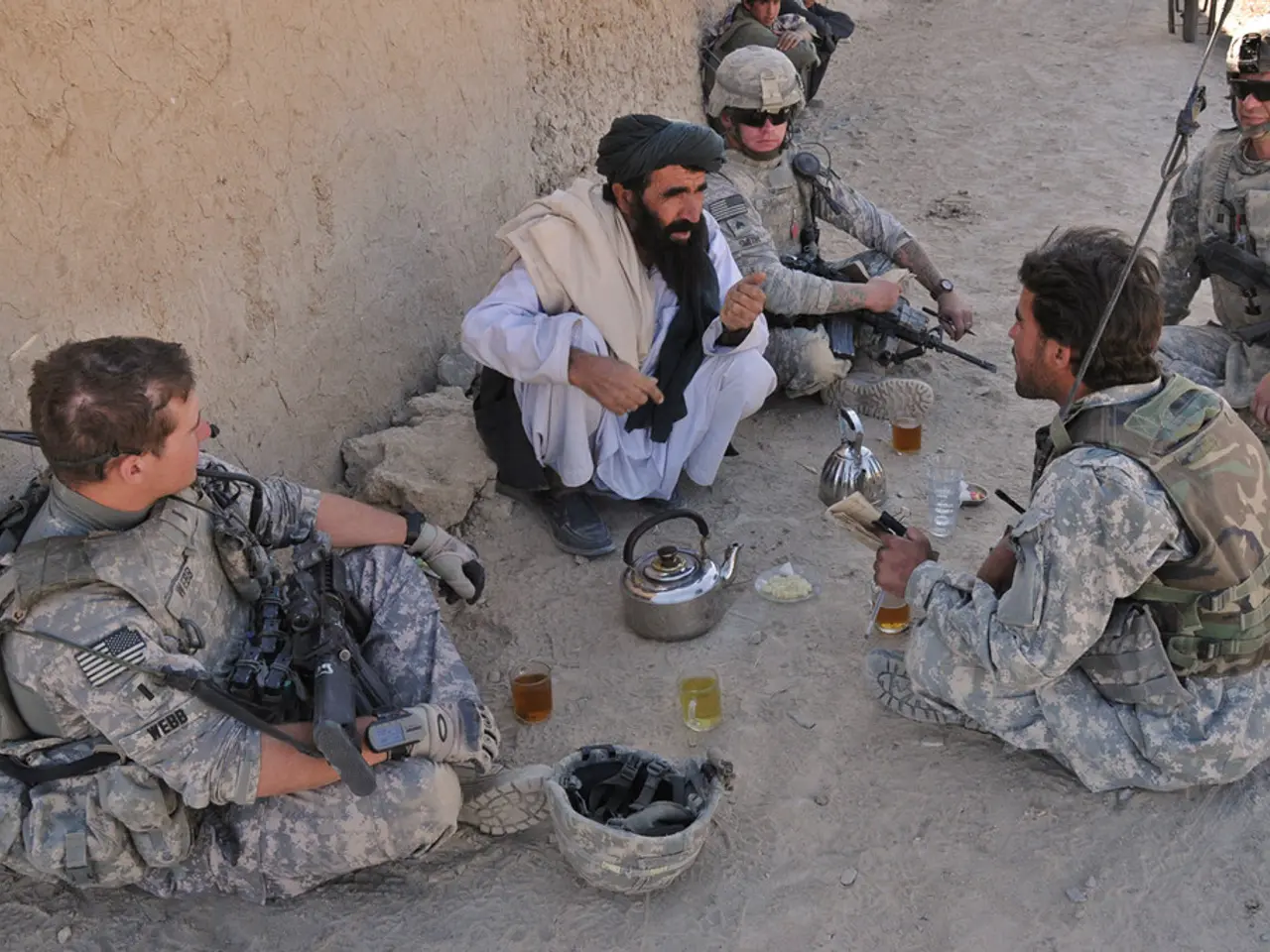 In this picture I can see there are a few people sitting, among them one is wearing a white shirt...