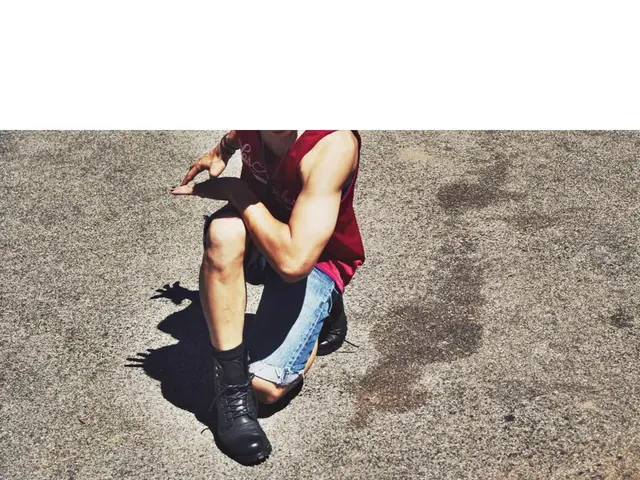 In this picture there is a person is on knee. At the bottom it looks like a road.