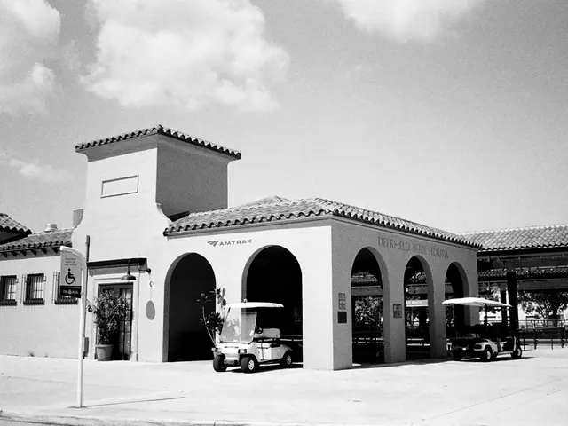 In this image in the back ground there are buildings and there are cars and there are persons...