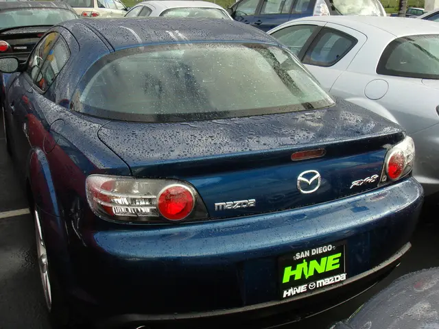 In this picture I can see few cars, at the bottom there is the board with the text on it.