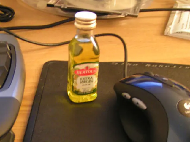 In this picture there is a table, on the table there are cables, mouse, keyboard, disc, notes,...